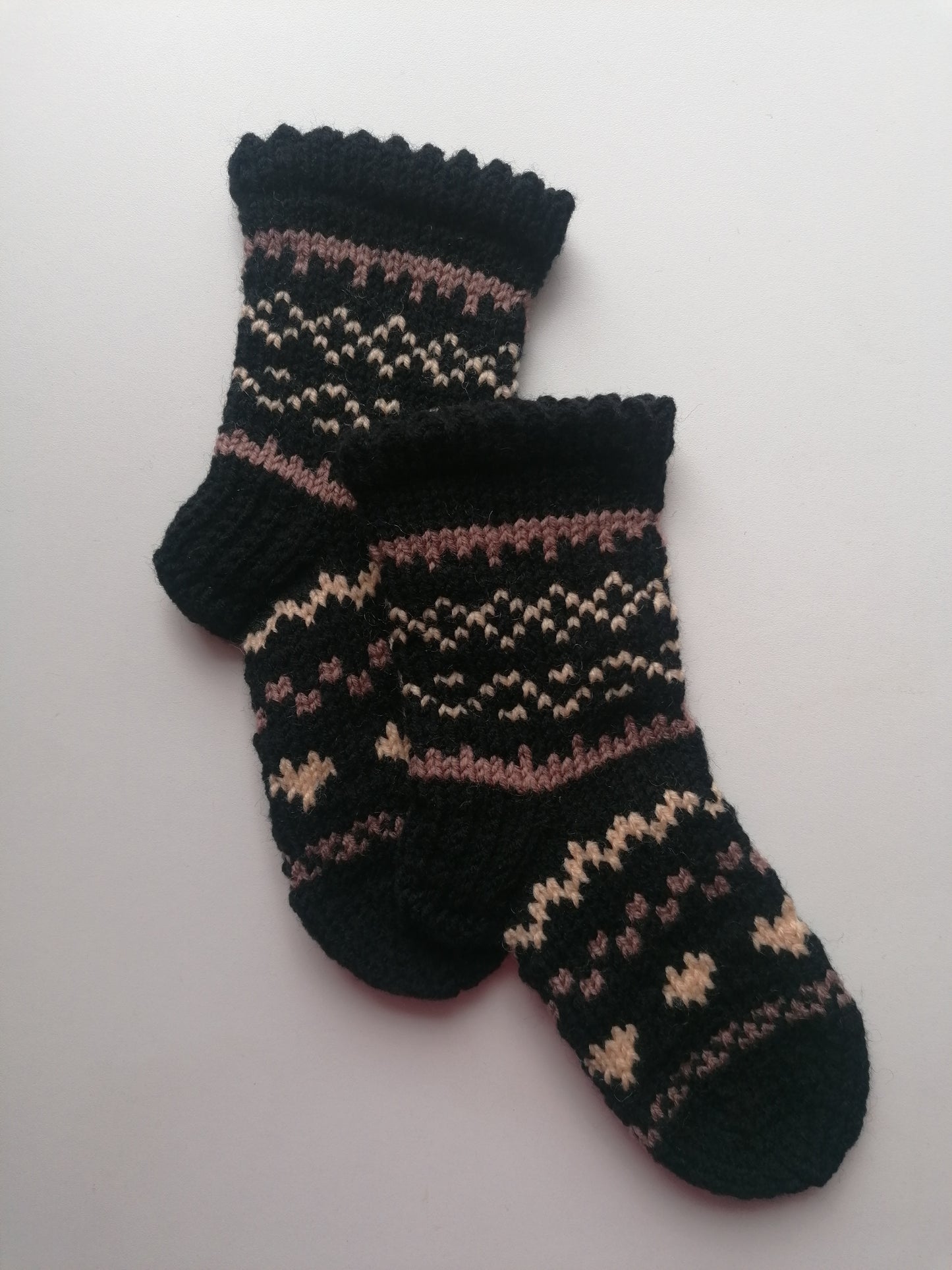 Pair of black socks with a pattern on a white background