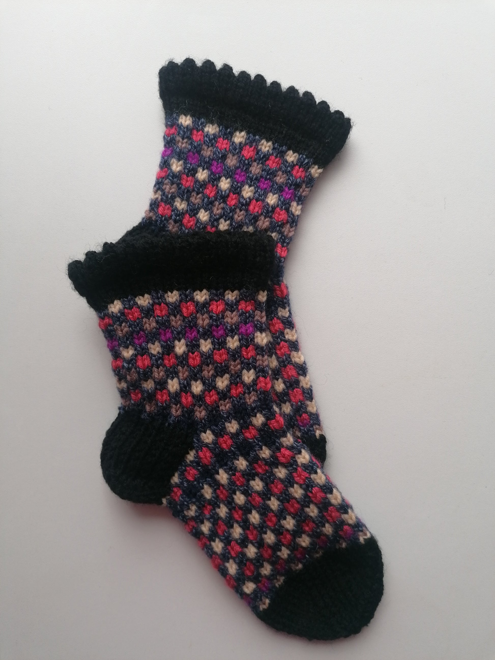 Pair of patterned socks with black trim on a white background