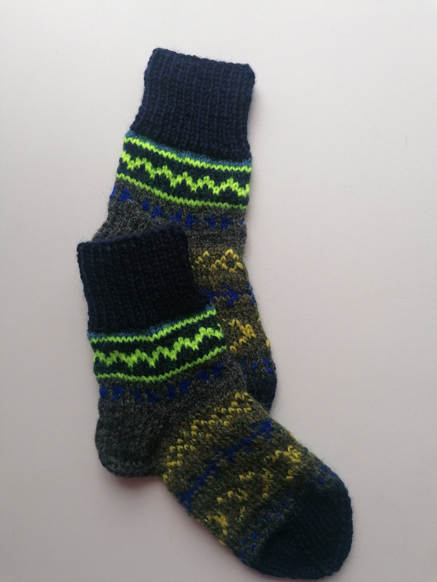 Knitted sock with green and blue pattern on a white background