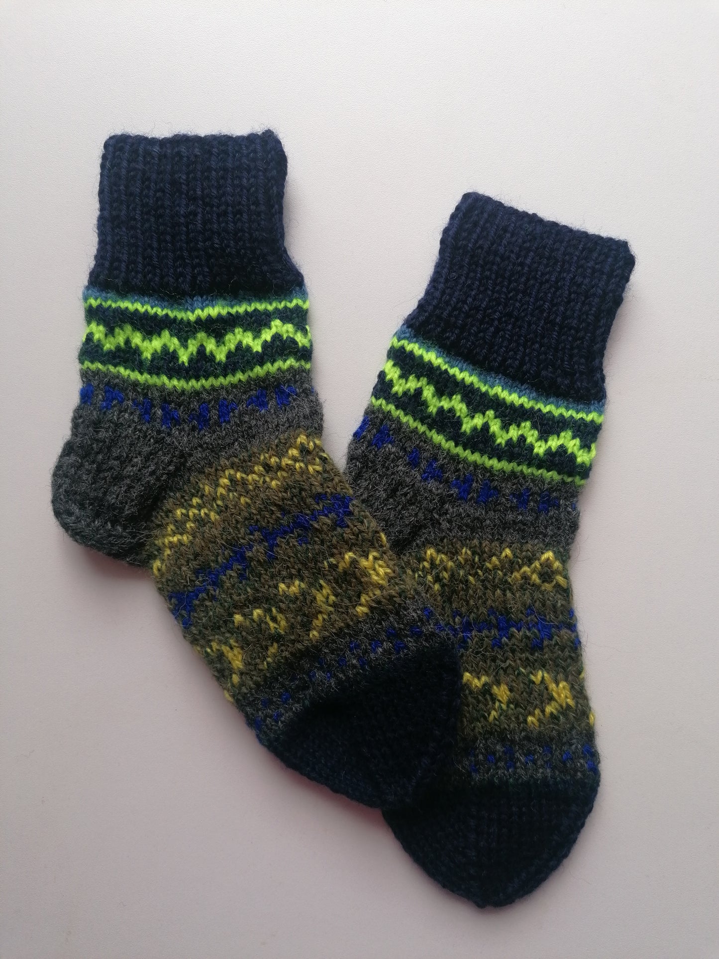 Pair of hand-knitted socks with a pattern on a white background