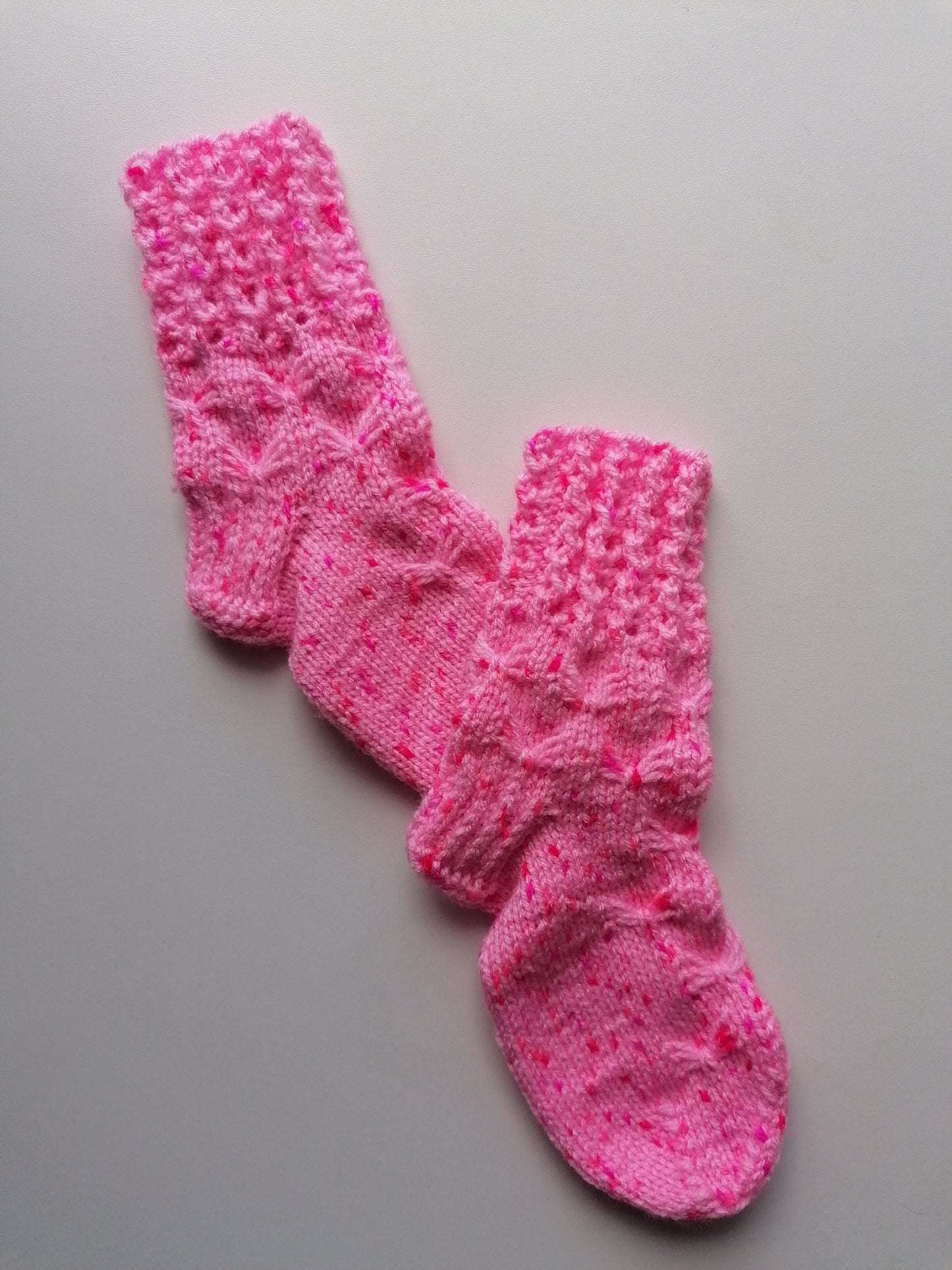 Pink knitted socks on a gray background