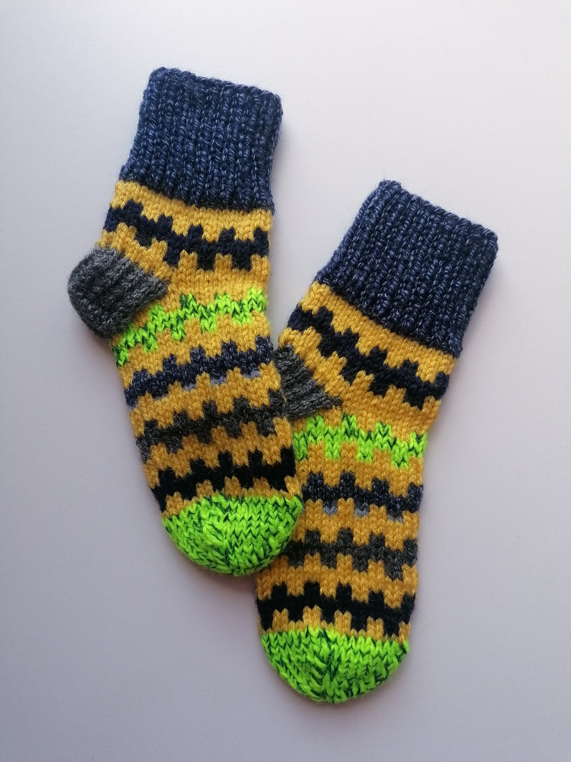 Pair of hand-knitted socks with a pattern on a white background