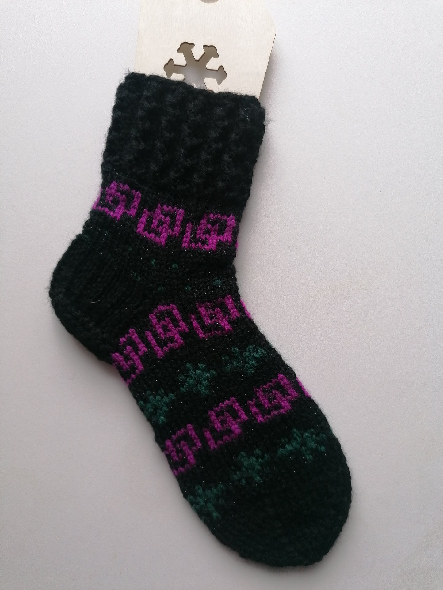 Black sock with pink and green pattern on a white background