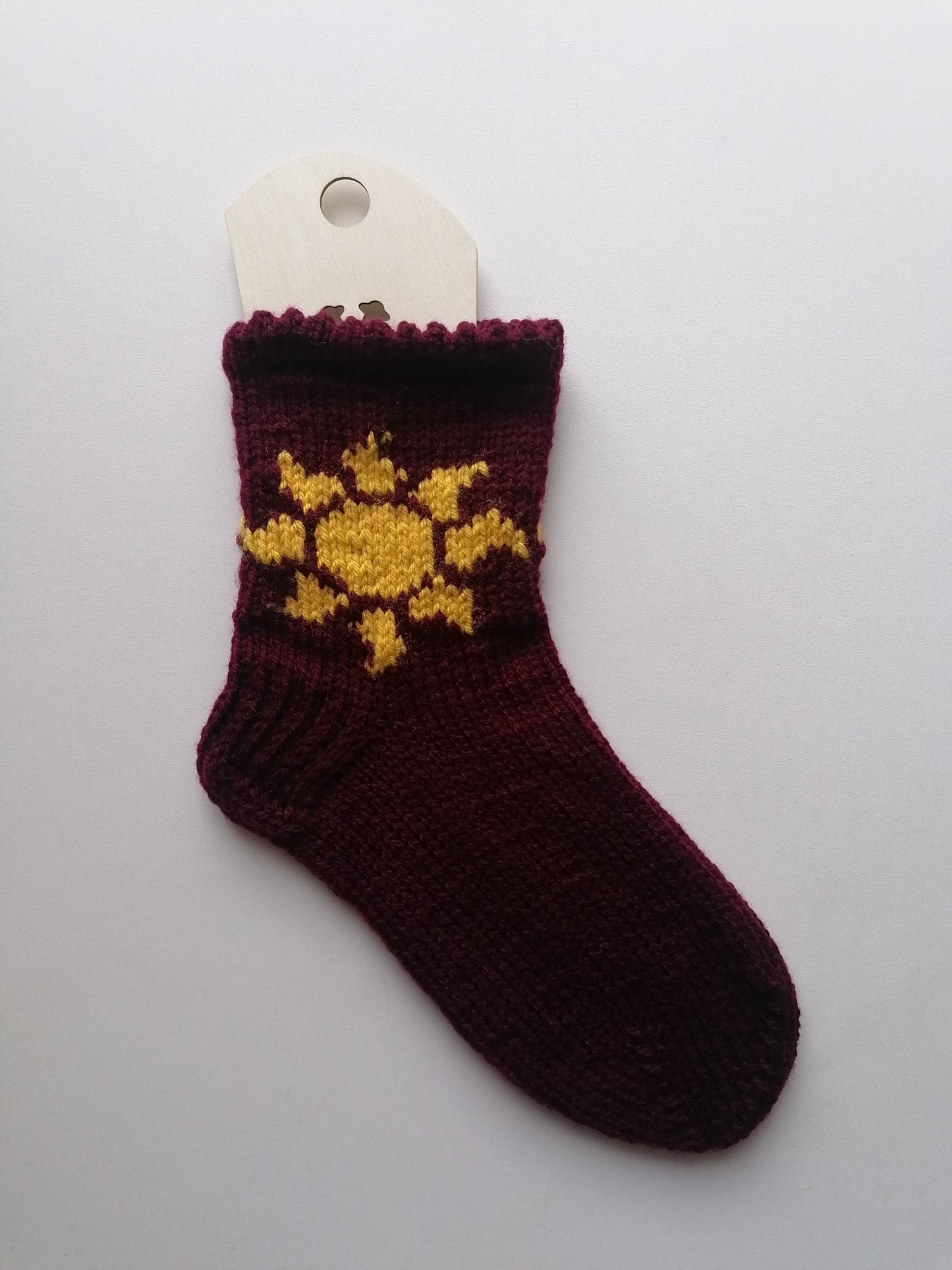 Knitted sock with yellow sun design on a white background