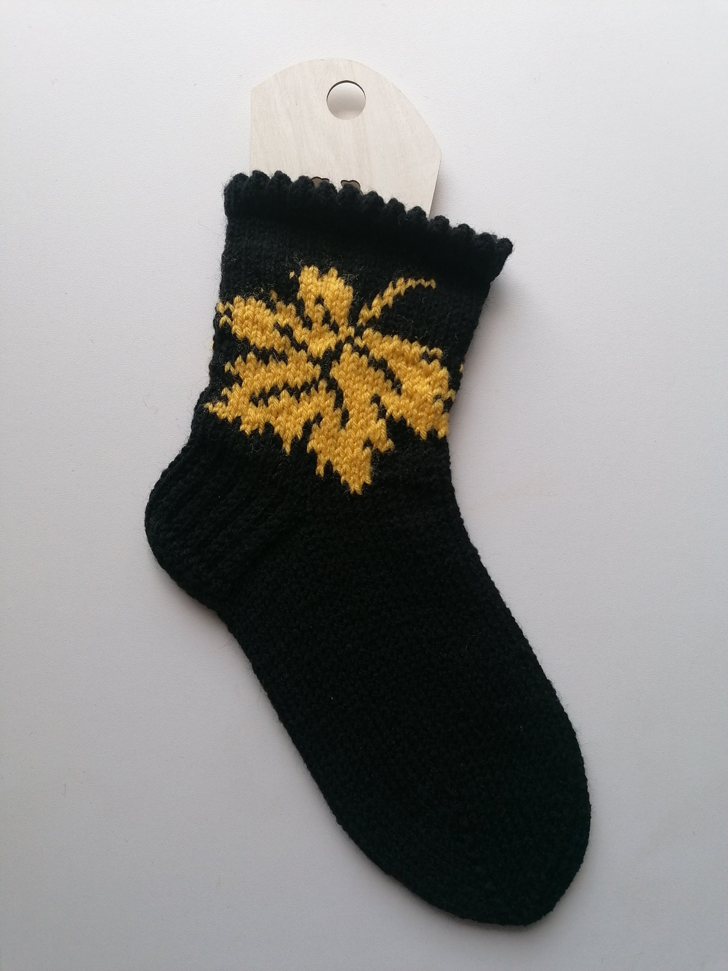 Black sock with yellow floral pattern on a white background