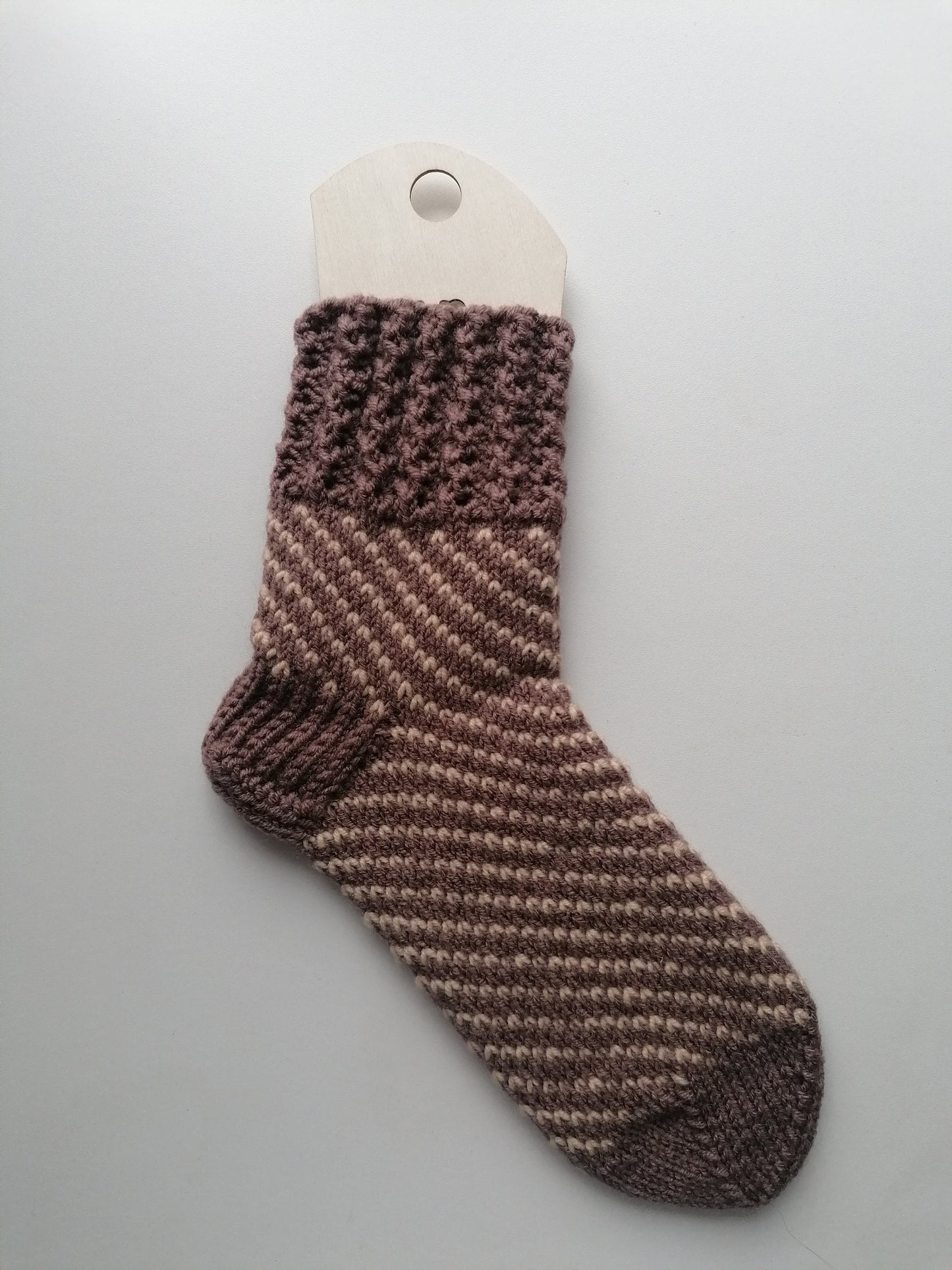 Knitted striped sock on a gray background