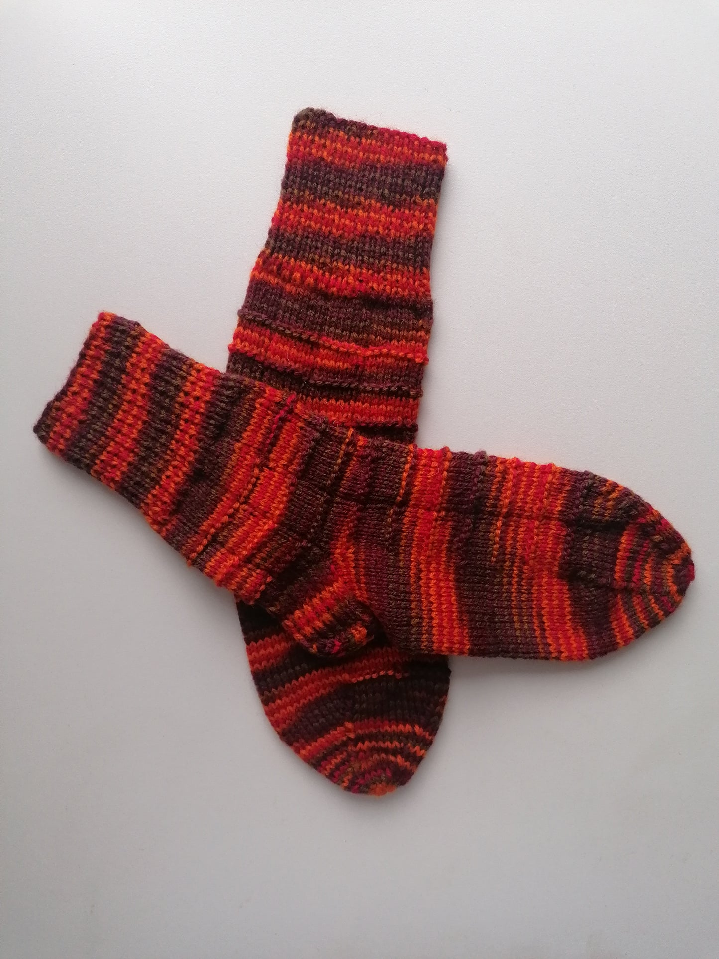 Pair of red and brown striped socks on a light gray background