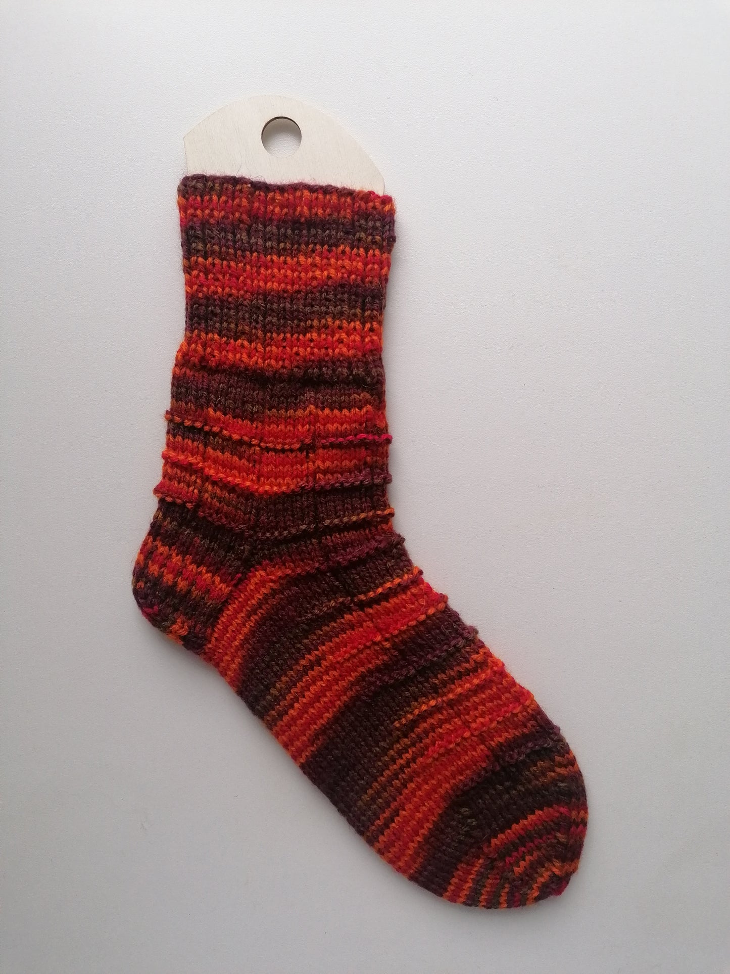Striped red and brown sock on a white background