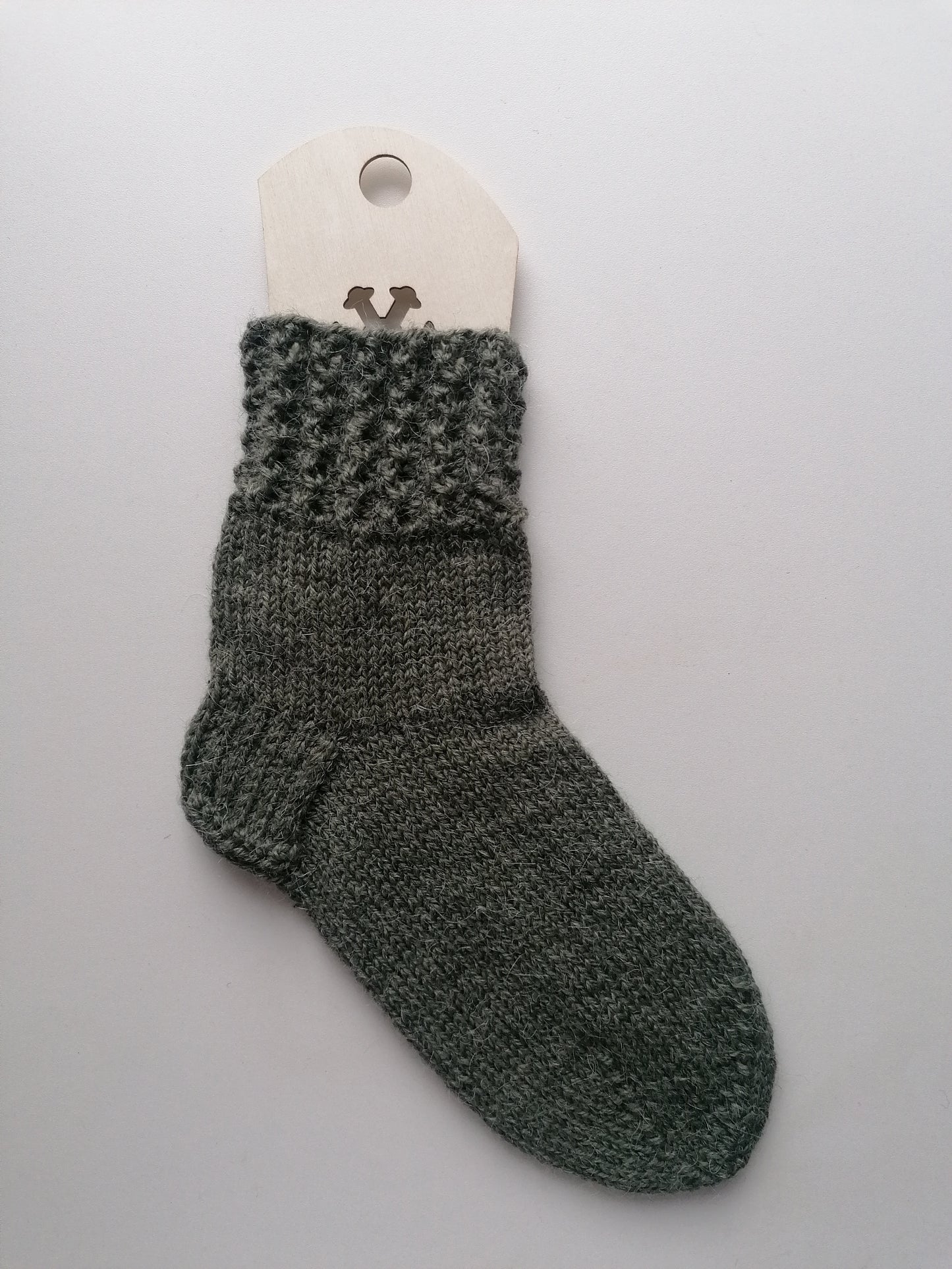Green knitted sock on a white background