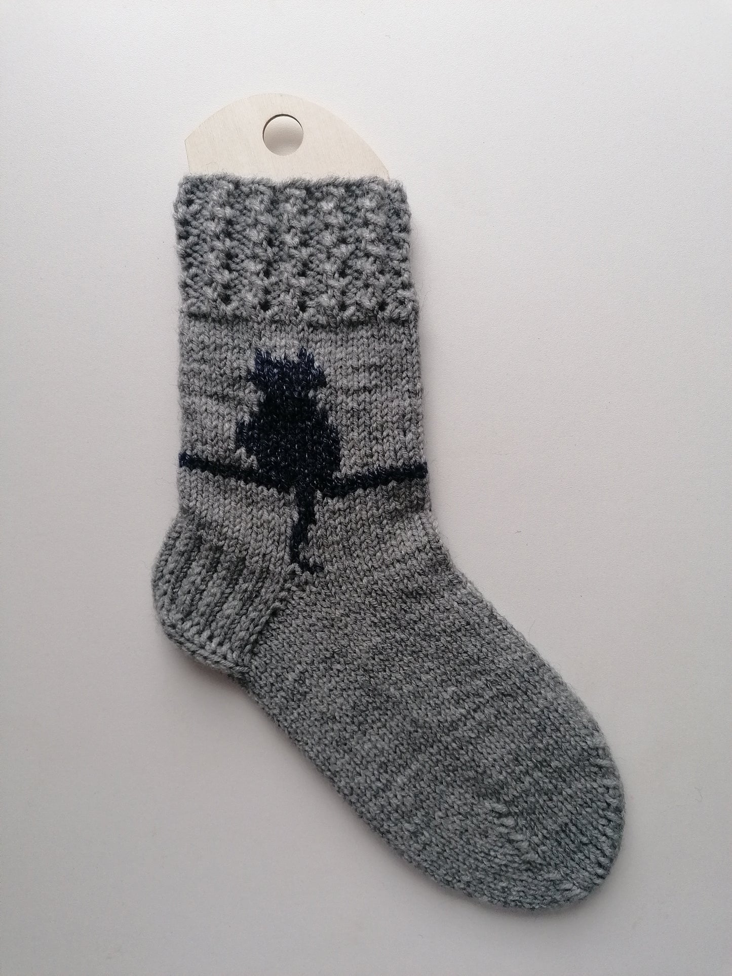 Gray sock with a cat design on a white background
