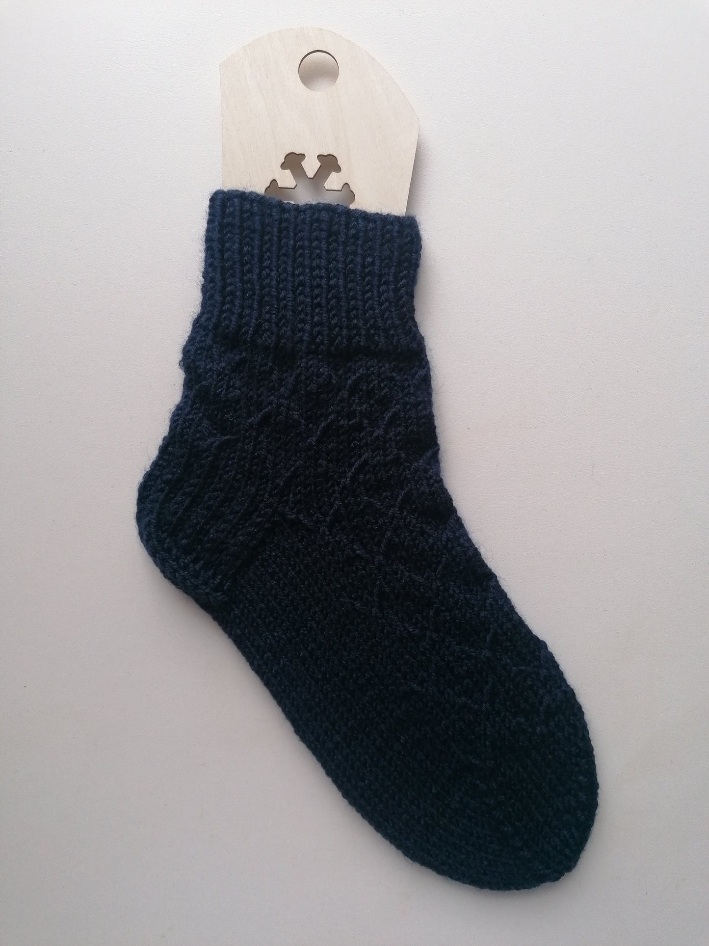 Dark blue knitted sock on a white background