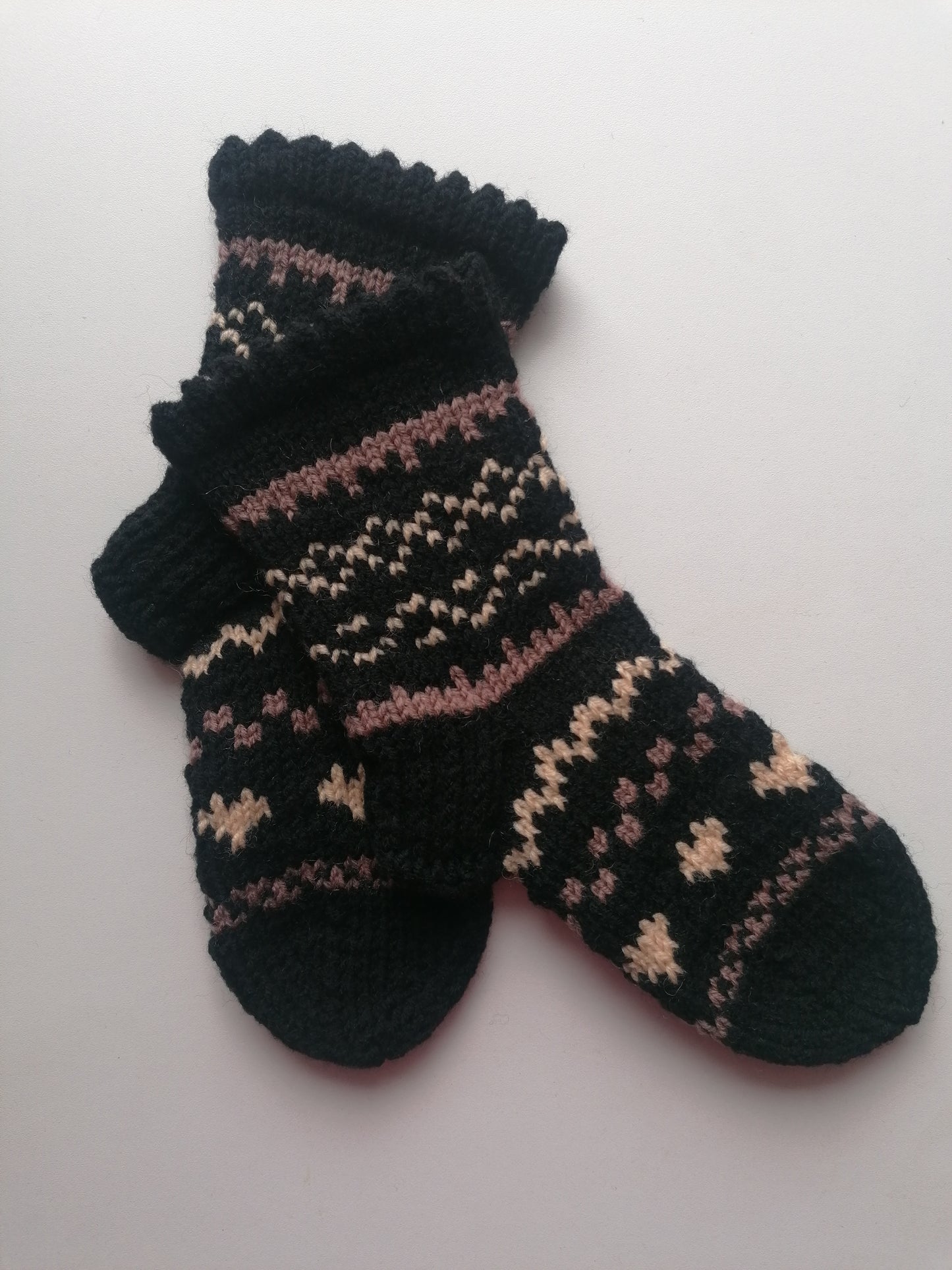 Black knitted sock with a pattern on a white background