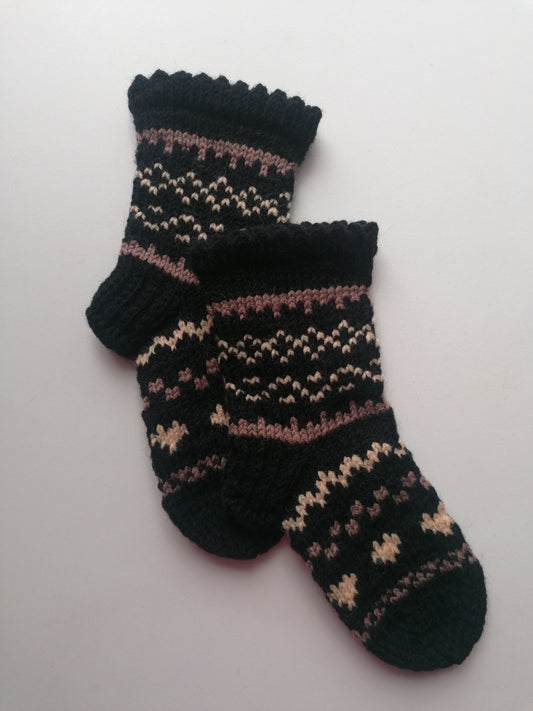 Pair of black socks with a pattern on a white background