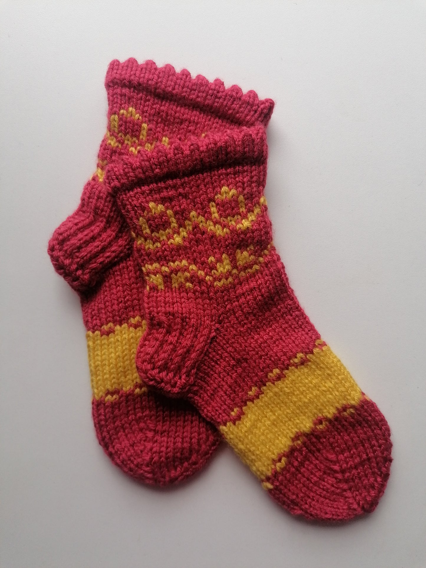 Pair of orange and yellow knitted socks on a light gray background