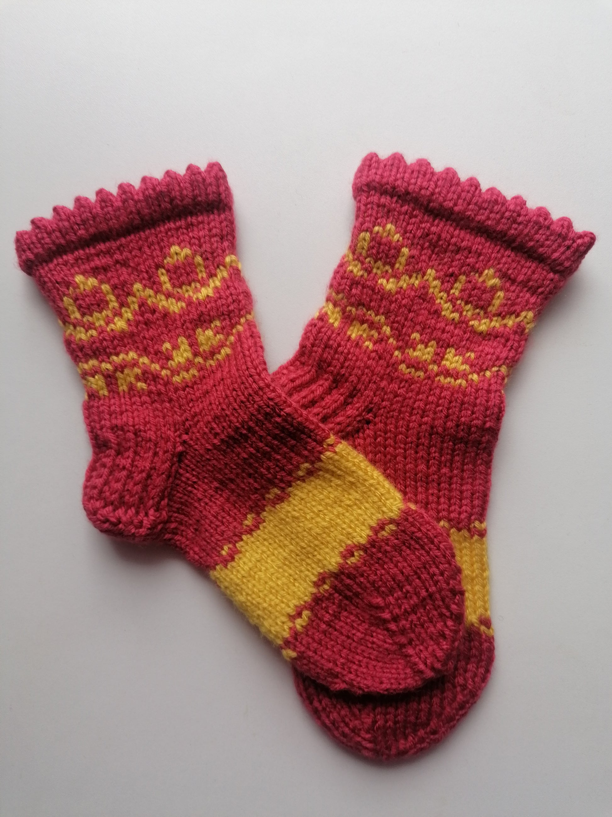 Pair of orange and yellow knitted socks on a light gray background