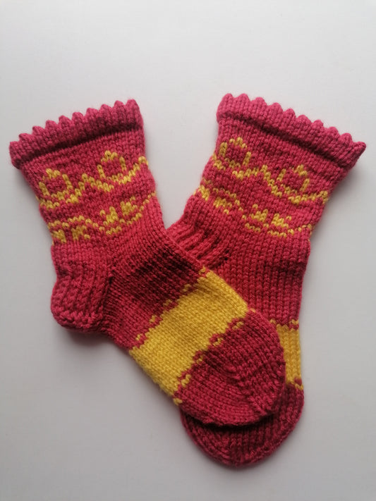 Pair of orange and yellow knitted socks on a light gray background