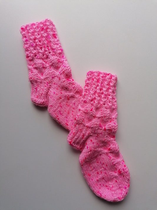 Pink knitted socks on a gray background