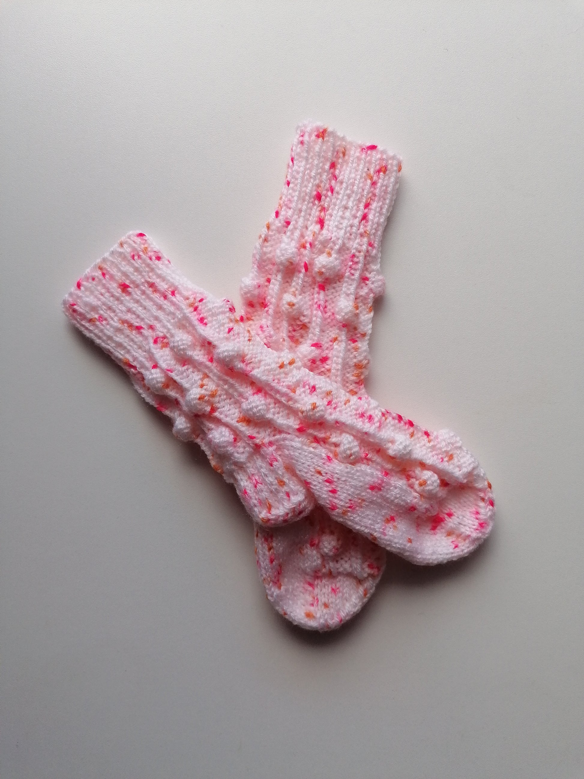 Pair of pink and white patterned socks on a gray background