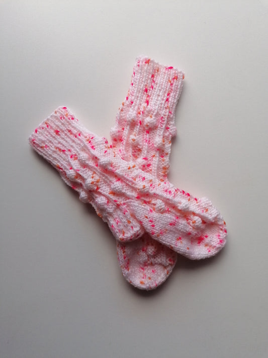 Pair of pink and white patterned socks on a gray background
