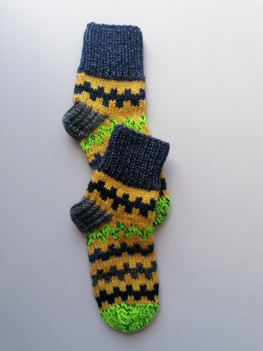 Knitted socks with a pattern of blue, yellow, and green on a light gray background