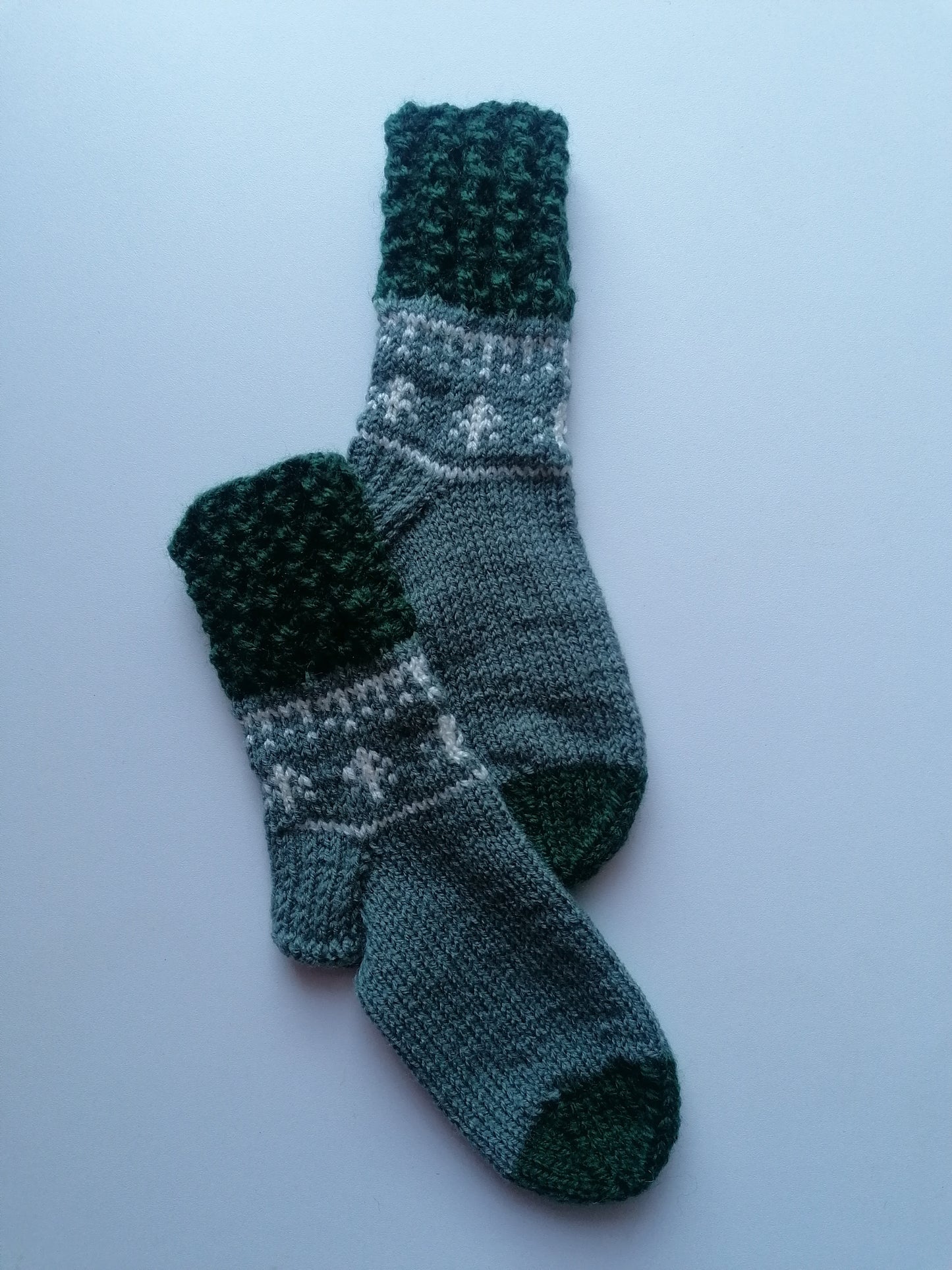Pair of knitted socks with a pattern on a light blue background