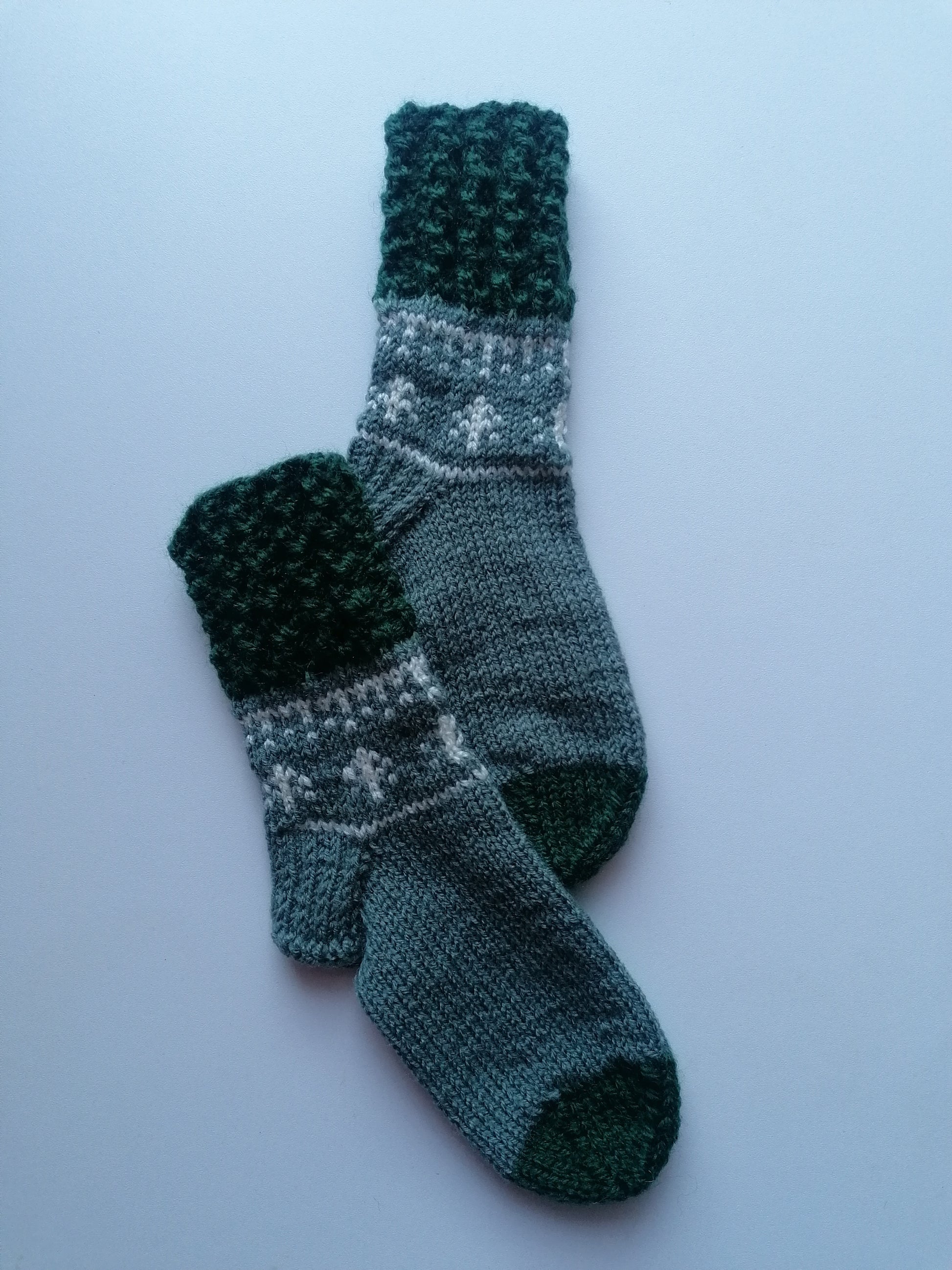 Pair of knitted socks with a pattern on a light blue background