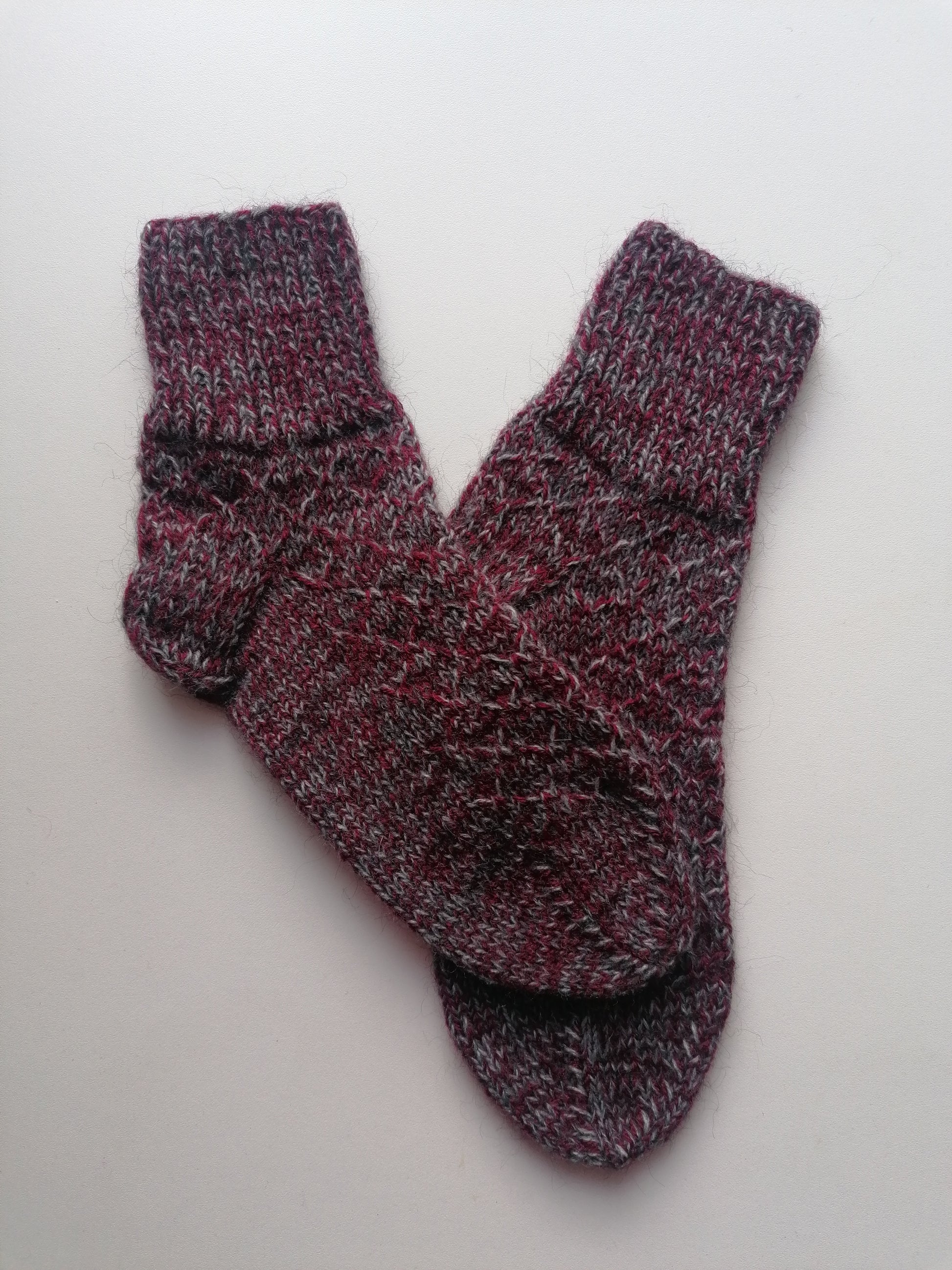 Pair of maroon and gray socks on a light gray background
