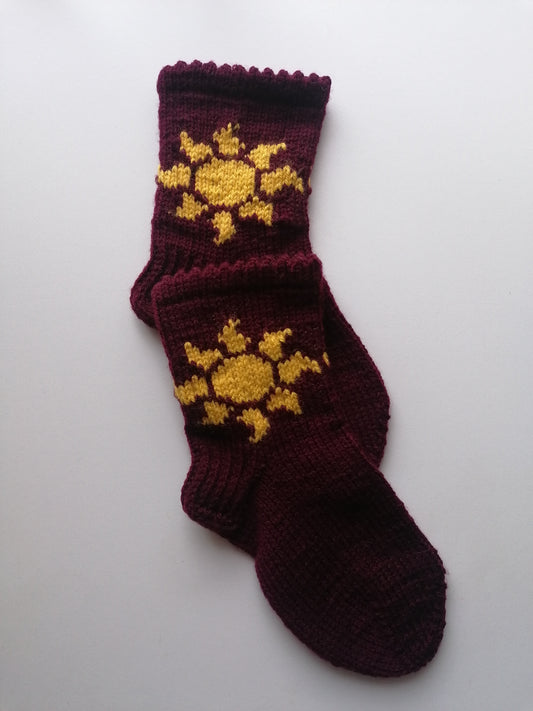 Knitted socks with yellow sun design on a white background