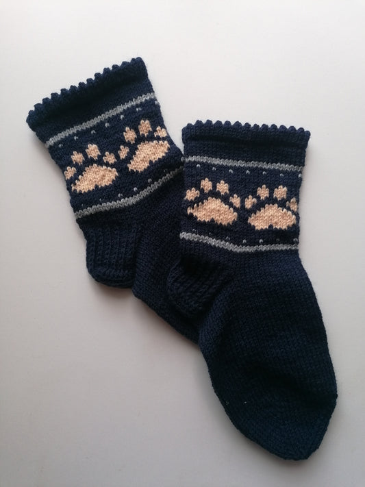 Pair of navy blue socks with pink paw prints on a light gray background