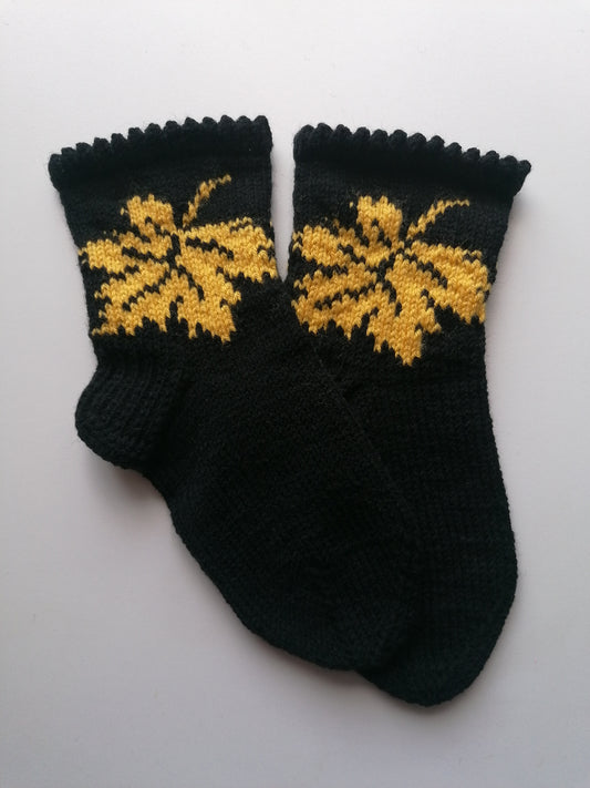 Black socks with yellow leaf patterns on a white background