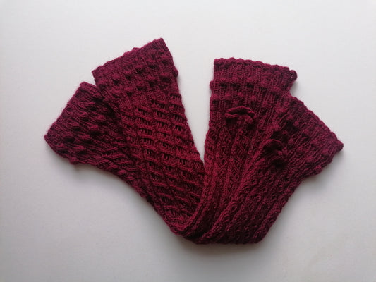 Pair of maroon knitted fingerless gloves on a white background