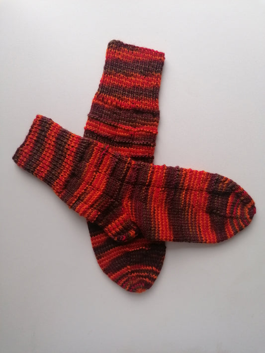 Pair of red and brown striped socks on a light gray background