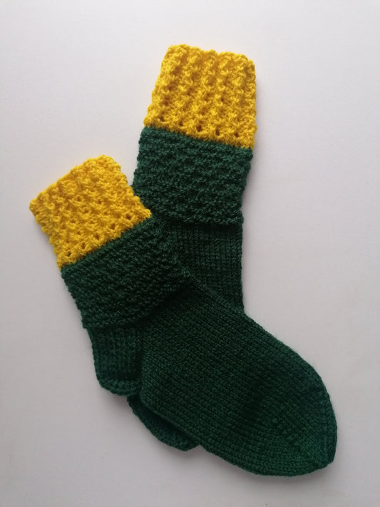 Green and yellow knitted socks on a white background