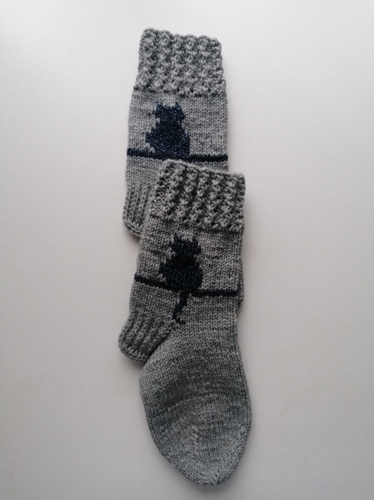 Pair of gray socks with cat design on a white background
