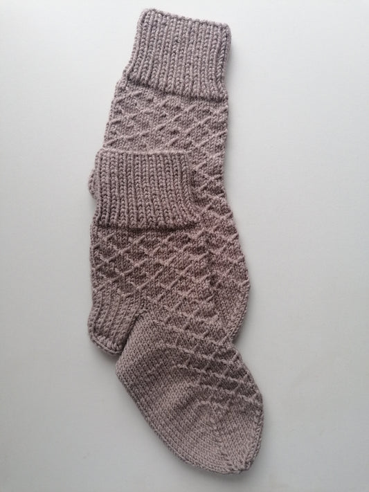 Knitted sock with a diamond pattern on a light gray background
